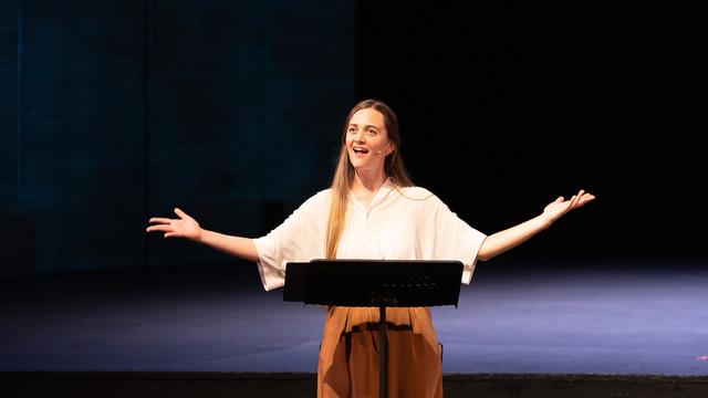 woman singing behind a music stand